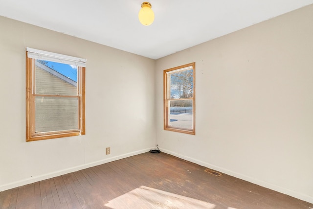 empty room with dark hardwood / wood-style flooring