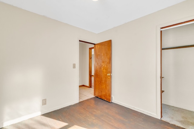 unfurnished bedroom with hardwood / wood-style flooring and a closet