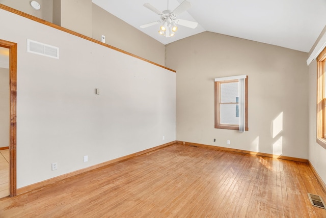 spare room featuring a wealth of natural light, vaulted ceiling, ceiling fan, and light wood-type flooring