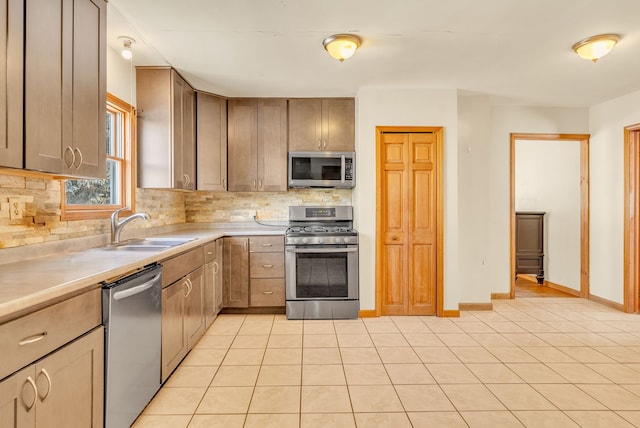 kitchen with tasteful backsplash, stainless steel appliances, sink, and light tile patterned floors