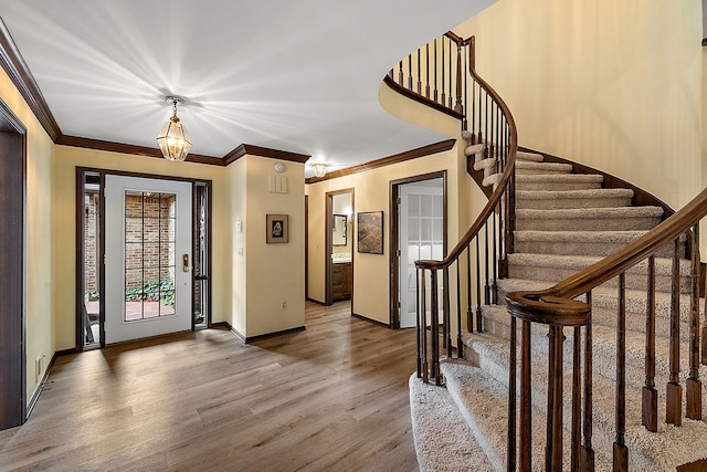 foyer featuring crown molding and hardwood / wood-style floors