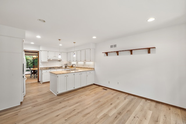 kitchen featuring white cabinetry, decorative backsplash, light stone counters, and pendant lighting