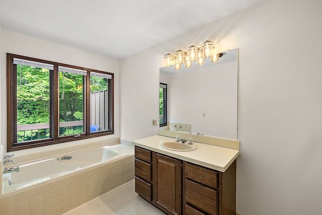 bathroom with tile patterned floors, vanity, and tiled tub