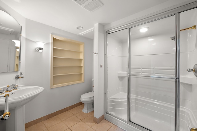 bathroom with sink, toilet, an enclosed shower, and tile patterned flooring