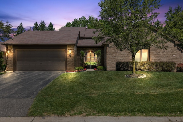 view of front of home featuring a garage and a lawn