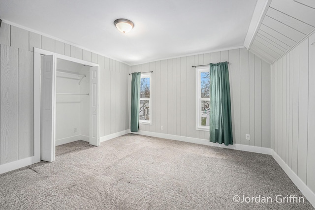 unfurnished bedroom featuring lofted ceiling, carpet floors, and a closet