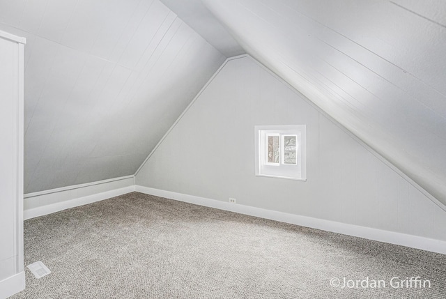 additional living space featuring lofted ceiling and carpet floors