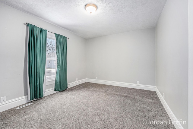 carpeted spare room with a textured ceiling