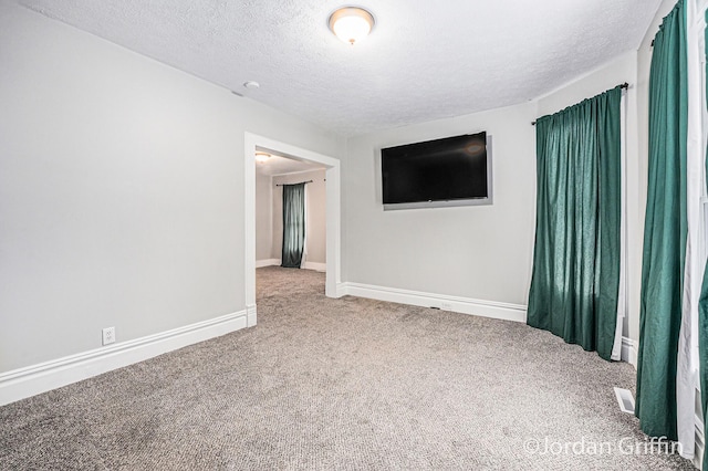 spare room with carpet flooring and a textured ceiling