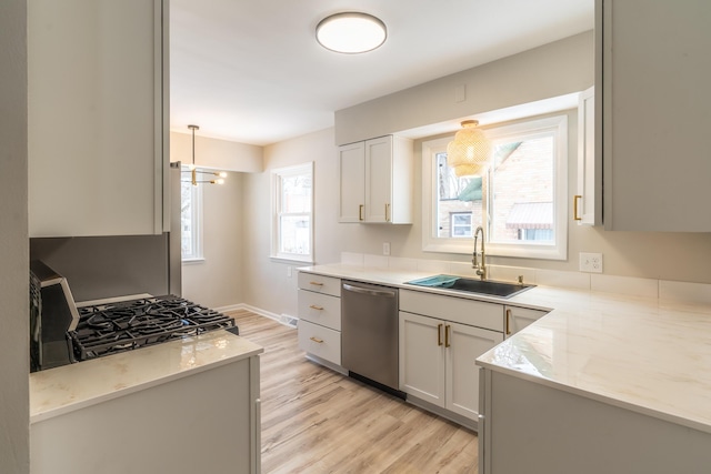 kitchen featuring sink, stainless steel dishwasher, range, light stone countertops, and light wood-type flooring