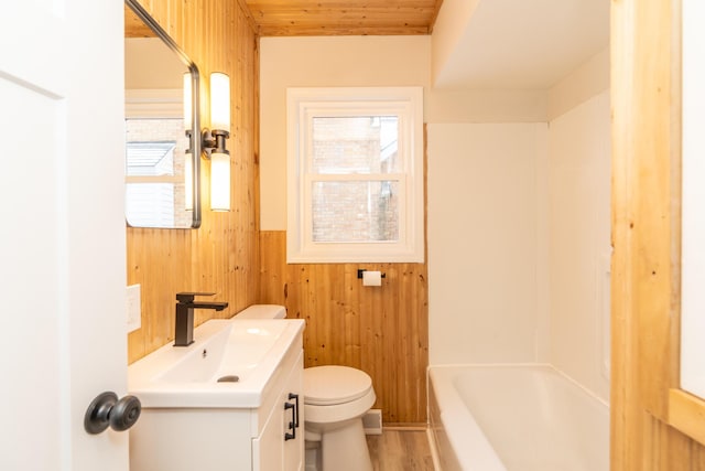 bathroom with wood walls, a tub, vanity, toilet, and wooden ceiling