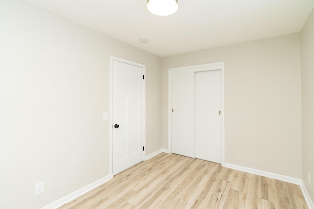 unfurnished bedroom with light hardwood / wood-style floors and a closet