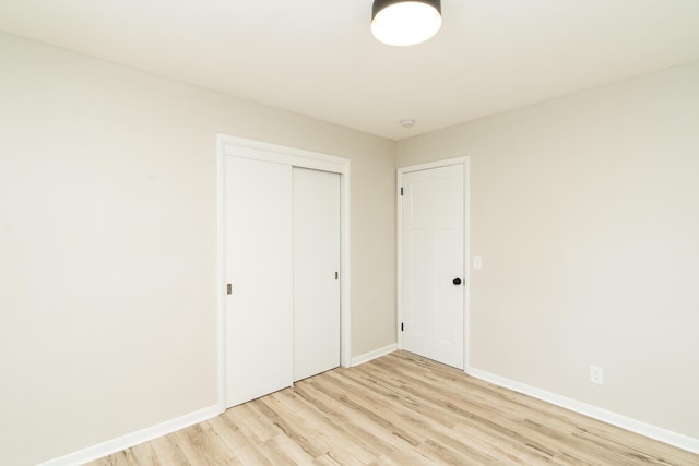 unfurnished bedroom with light hardwood / wood-style floors and a closet