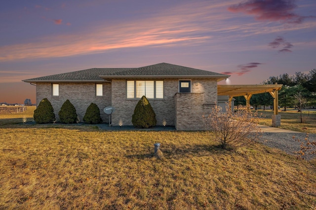 property exterior at dusk featuring a lawn