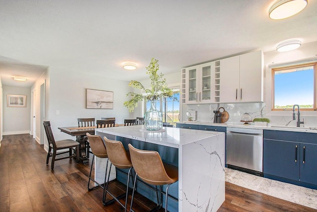 kitchen featuring a kitchen island, blue cabinets, white cabinetry, sink, and stainless steel dishwasher