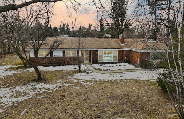 ranch-style home with brick siding and a chimney