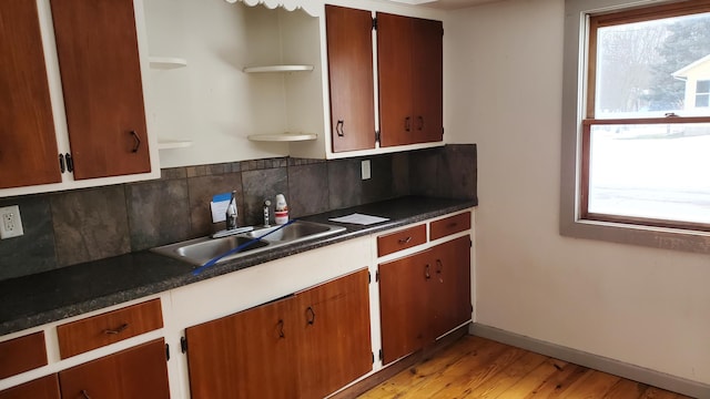 kitchen with sink, backsplash, and light wood-type flooring