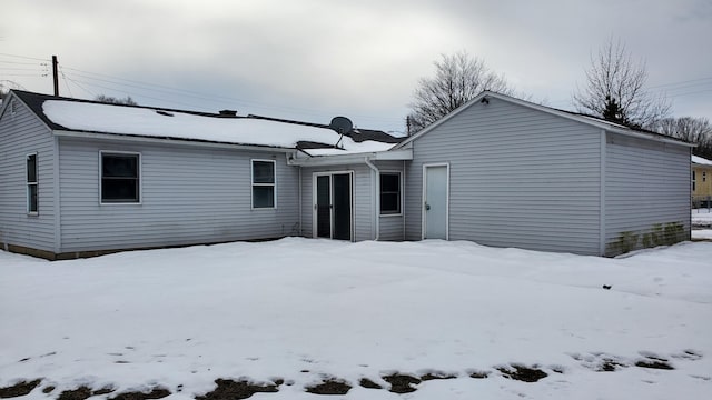 view of snow covered rear of property