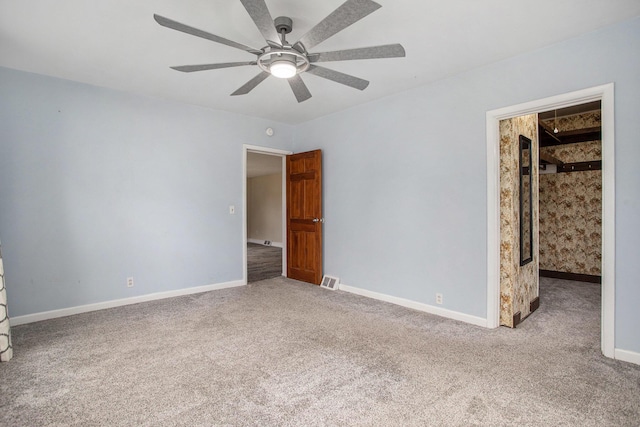 unfurnished bedroom featuring ceiling fan, light colored carpet, and a spacious closet