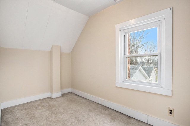 additional living space featuring lofted ceiling and light colored carpet