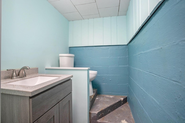 bathroom with vanity, toilet, and concrete floors