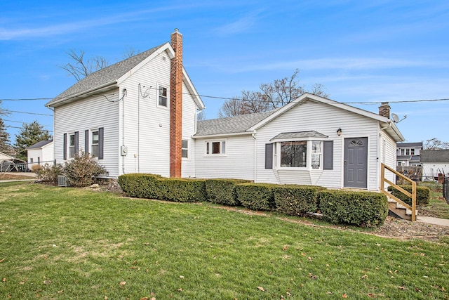 view of front of home featuring central AC unit and a front yard