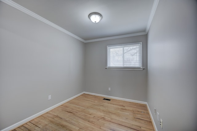 spare room featuring ornamental molding and light hardwood / wood-style flooring