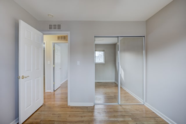 unfurnished bedroom with a closet and light wood-type flooring