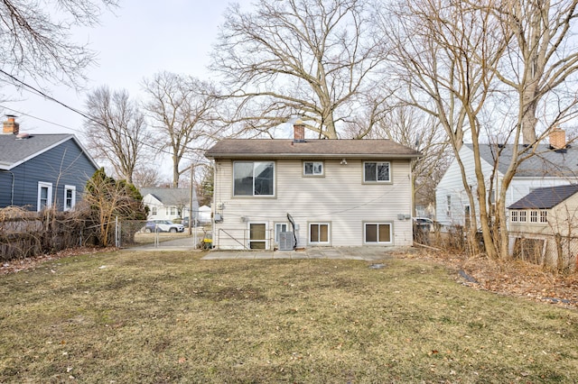 rear view of house featuring central AC unit, a yard, and a patio