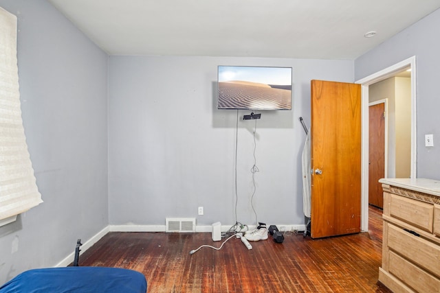 bedroom with dark hardwood / wood-style floors