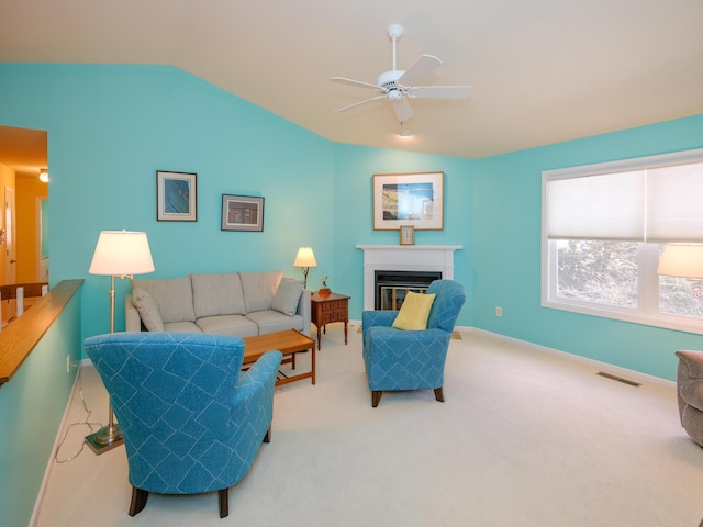 carpeted living room with ceiling fan and lofted ceiling