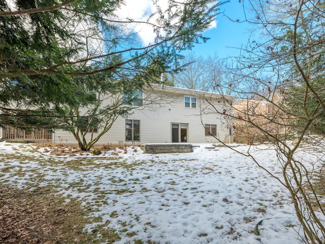 view of snow covered rear of property