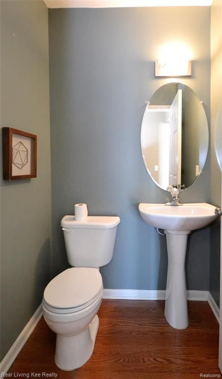 bathroom with hardwood / wood-style flooring and toilet