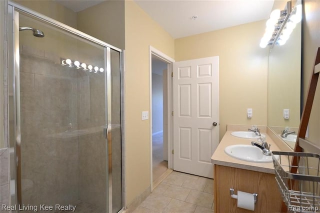 bathroom featuring tile patterned flooring, vanity, and a shower with shower door