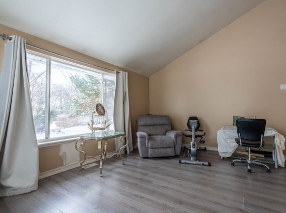 office space with baseboards, vaulted ceiling, and wood finished floors