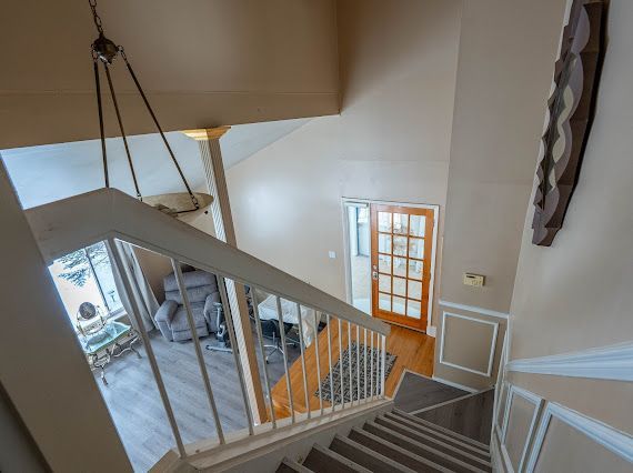 staircase featuring a high ceiling and wood finished floors