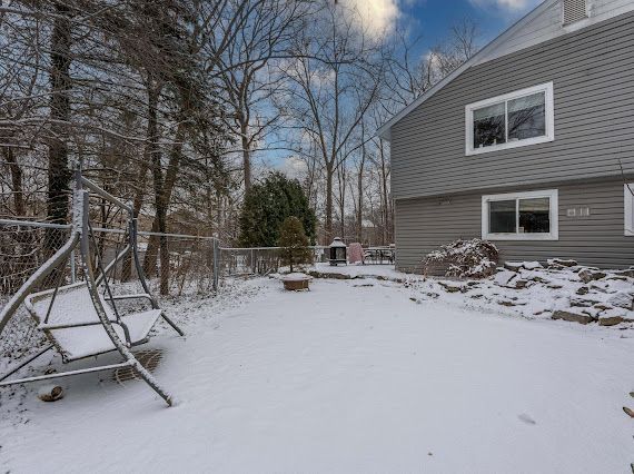 yard layered in snow featuring fence