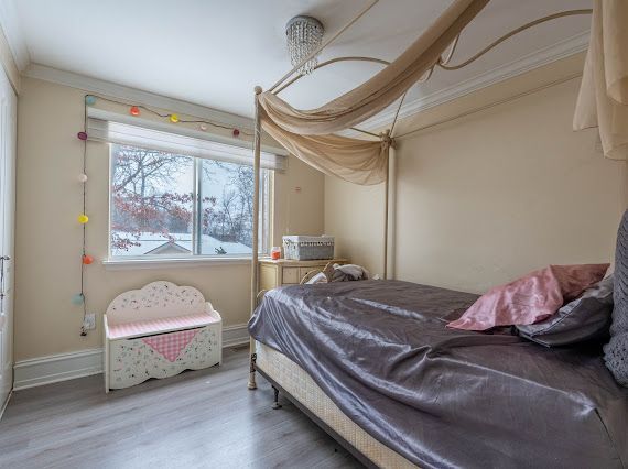 bedroom with crown molding, baseboards, and wood finished floors