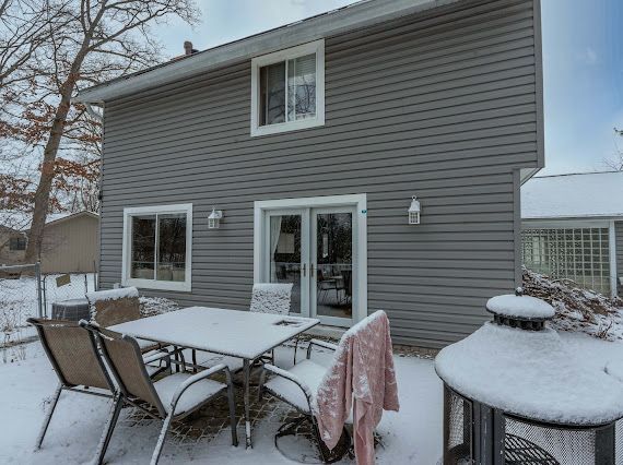 snow covered house featuring outdoor dining space