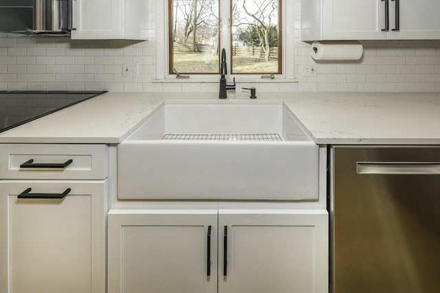 kitchen featuring backsplash, light stone countertops, sink, and white cabinets