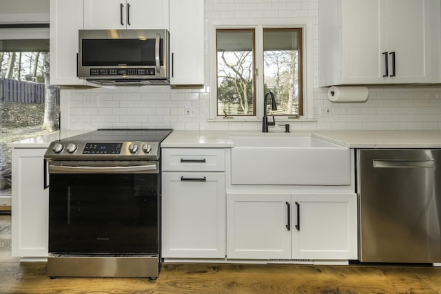 kitchen featuring sink, a wealth of natural light, stainless steel appliances, and white cabinets