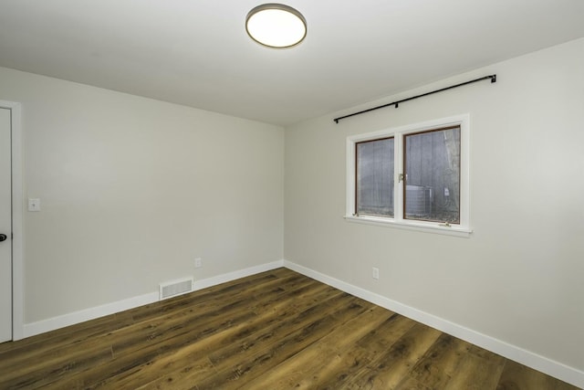 empty room with dark hardwood / wood-style flooring