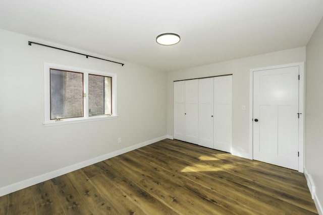 unfurnished bedroom with dark hardwood / wood-style floors and a closet