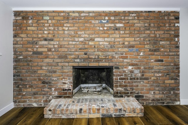 details with wood-type flooring and a brick fireplace