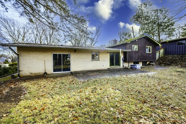 rear view of house featuring a patio area and a lawn