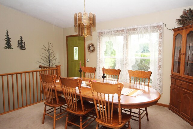 dining space featuring an inviting chandelier and light carpet