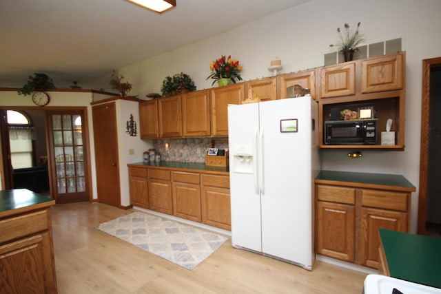 14523 E V Ave, Fulton, MI 49052 - kitchen featuring white fridge with ice dispenser, black microwave, light wood finished floors, and tasteful backsplash