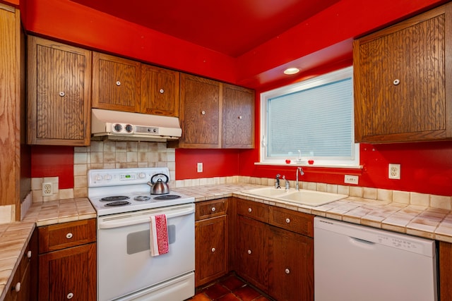 kitchen with white appliances, tile counters, sink, and decorative backsplash