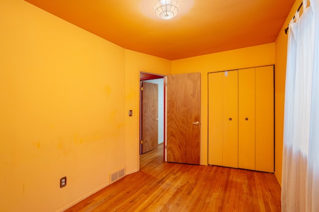 unfurnished bedroom with light hardwood / wood-style floors and a closet