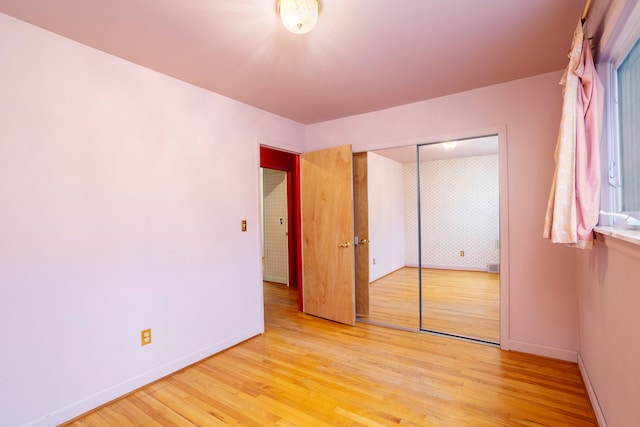 unfurnished bedroom with a closet and light hardwood / wood-style flooring